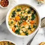 Rustic bowl of creamy Tuscan white bean soup with carrots and kale