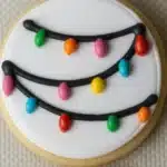 Icing Sugar Cookies decorated with white royal icing and colorful Christmas lights