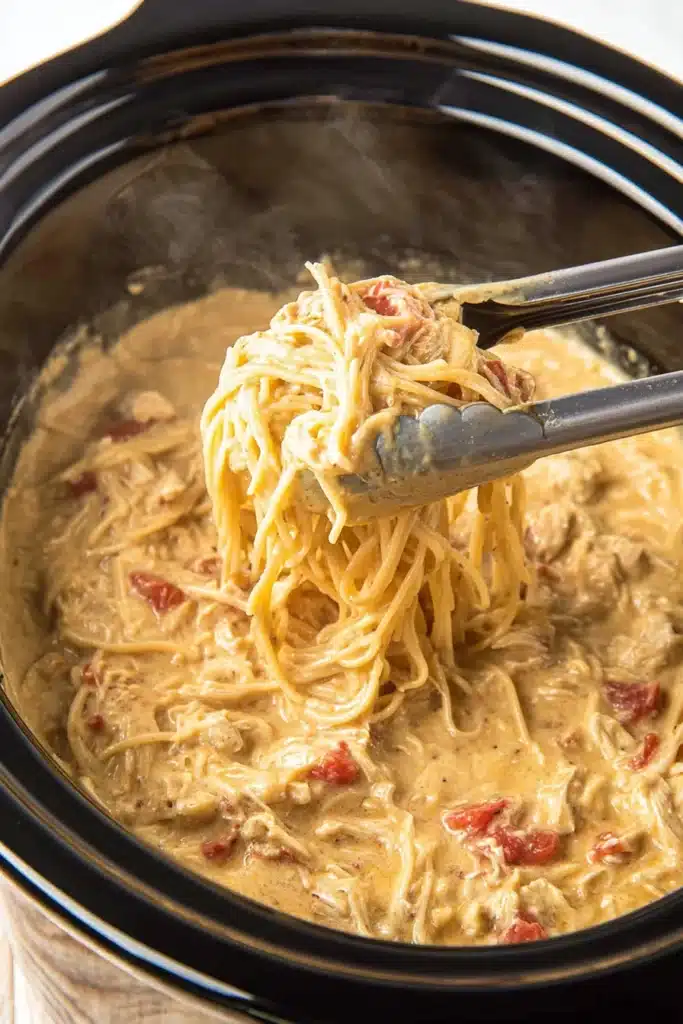 Easy Crockpot Chicken Spaghetti cooking in slow cooker with creamy sauce