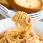 Easy Crockpot Chicken Spaghetti served with garlic bread slices