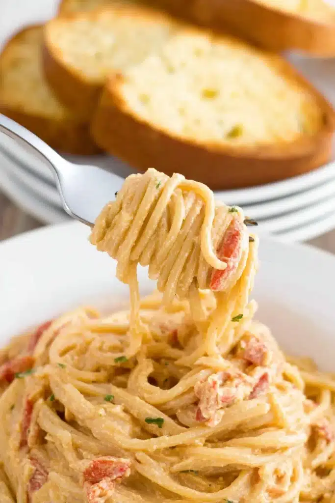 Easy Crockpot Chicken Spaghetti served with garlic bread slices