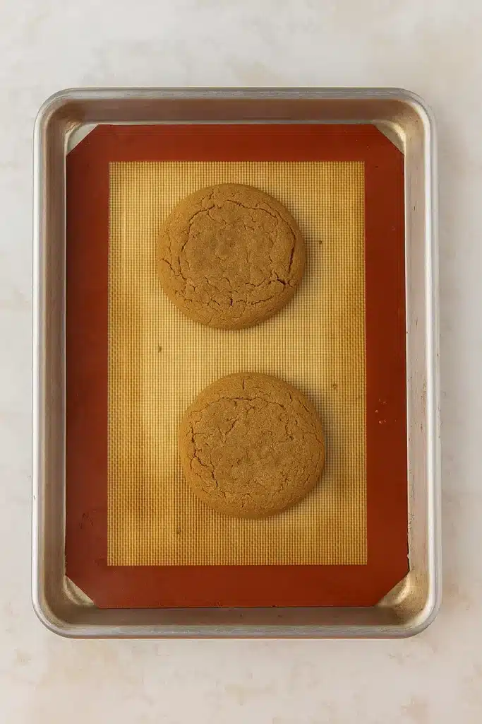 Amazing Crumbl Gingerbread Cookies Copycat Recipe 16 Baked Crumbl gingerbread cookies on baking sheet cooling before frosting