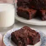 Brownie recipe featuring fudgy chocolate brownie on a plate with milk