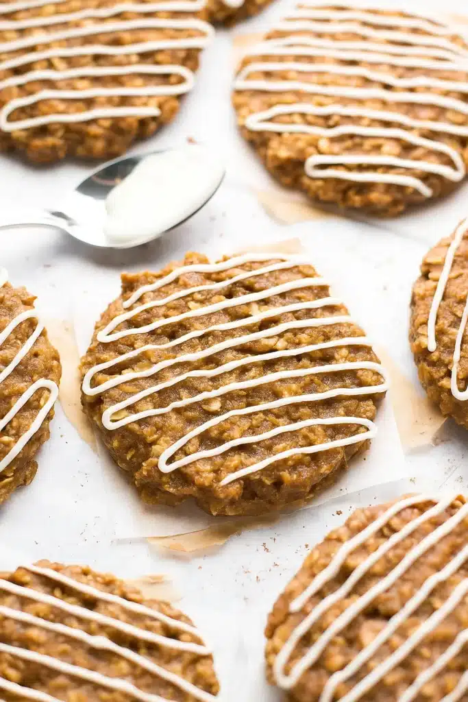 Gingerbread Oatmeal Cookies: Amazing Soft Holiday Treats 11 Soft gingerbread oatmeal cookies drizzled with white icing on parchment paper