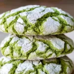 Stack of green Grinch crinkle cookies dusted with powdered sugar
