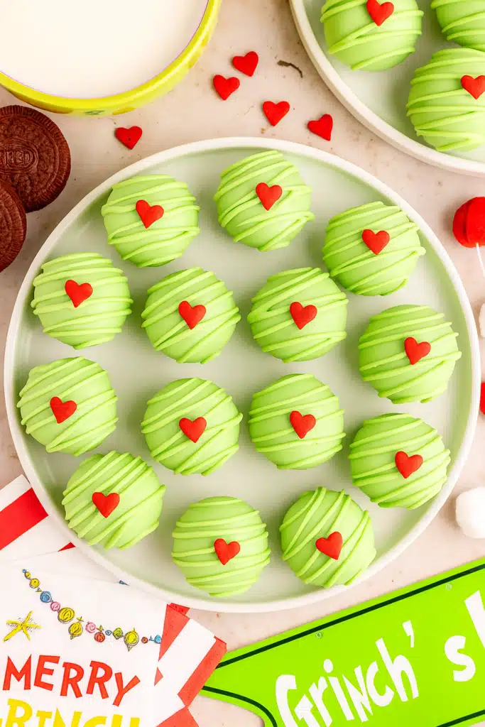 Grinch Oreo Balls – Easy, Festive & Delicious Treats 11 Top-down view of Grinch Oreo Balls with red hearts on white plate