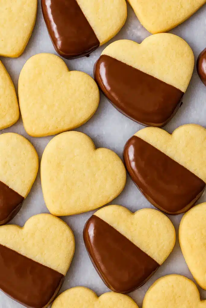 Shortbread Cookie Recipe | Simple & Delicious Holiday Treat 8 Heart-shaped shortbread cookies dipped in dark chocolate on marble surface