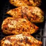 Juicy golden-brown air fryer chicken breasts in basket with crispy seasoning