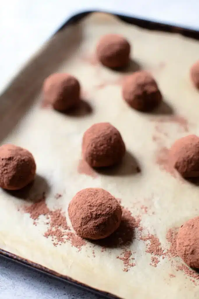 Peppermint Truffles – Easy, Delicious, and Festive Treats 20 Rolled chocolate truffles on parchment paper before coating