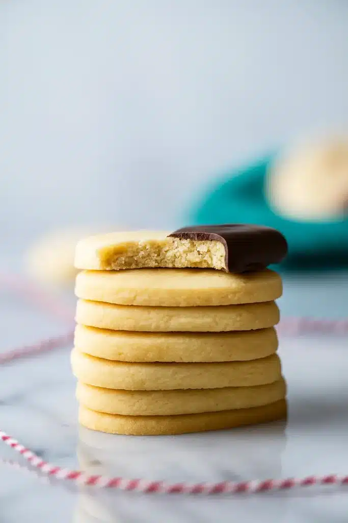 Shortbread Cookie Recipe | Simple & Delicious Holiday Treat 11 Stack of shortbread cookies with top cookie dipped in chocolate and bitten