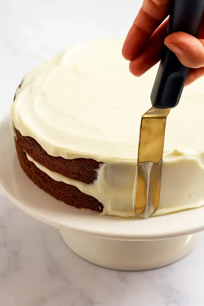 The BEST Carrot Cake Recipe | Irresistibly Moist & Flavorful 30 The BEST Carrot Cake slice on a white plate with cream cheese frosting