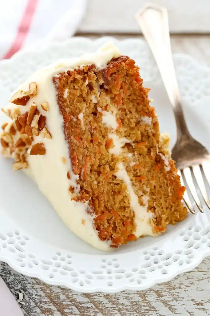 The BEST Carrot Cake Recipe | Irresistibly Moist & Flavorful 21 The BEST Carrot Cake slice with cream cheese frosting and chopped pecans