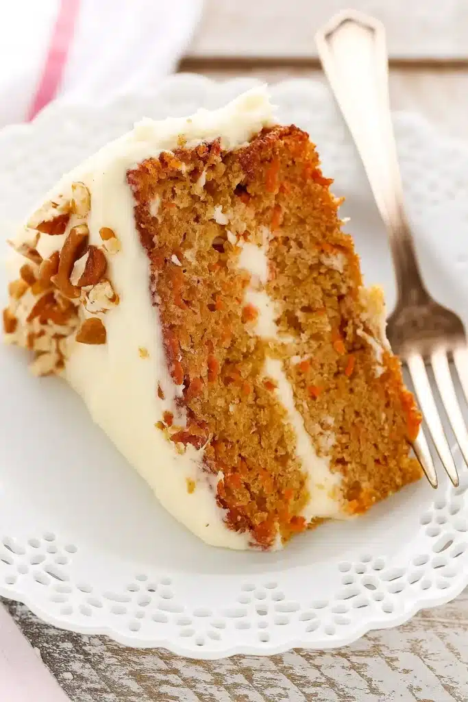The BEST Carrot Cake Recipe | Irresistibly Moist & Flavorful 32 The BEST Carrot Cake slice with cream cheese frosting and chopped pecans