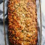 Golden-brown vegetarian meatloaf with crispy top in glass baking dish