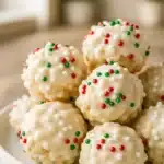 Rice Crispy Treats coated in white chocolate and topped with red and green sprinkles