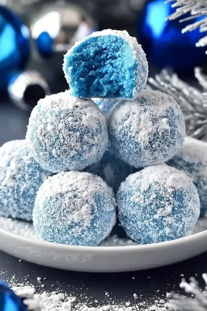 Blue Christmas truffles dusted with powdered sugar on a white plate