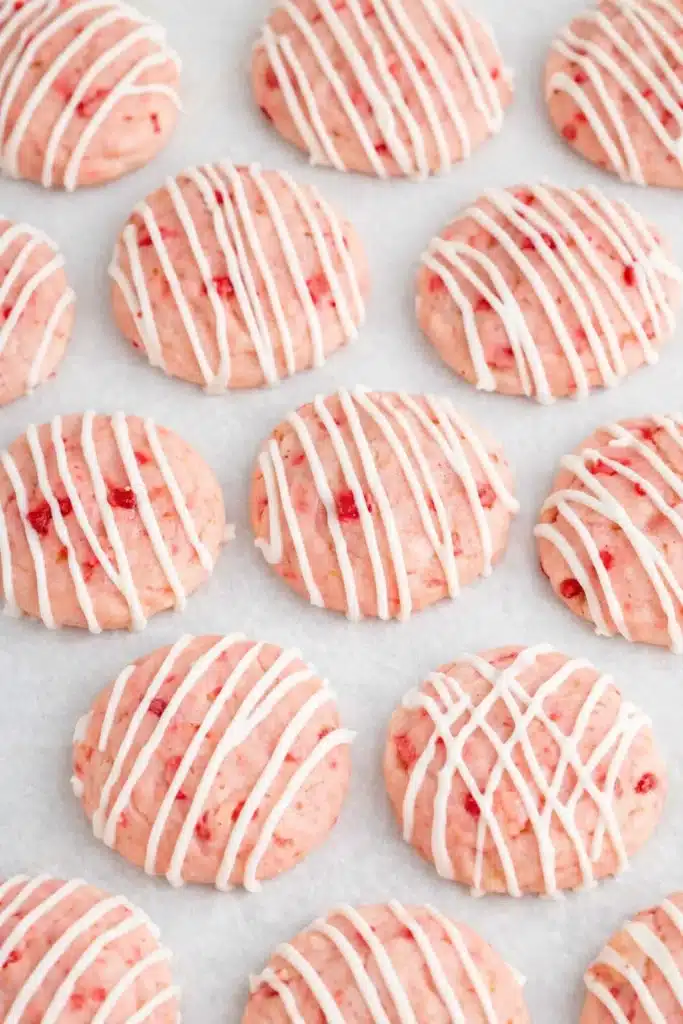 Cherry Almond Cookies | Simple, Sweet & Irresistible Treats 7 Cherry almond cookies with white chocolate drizzle on parchment paper