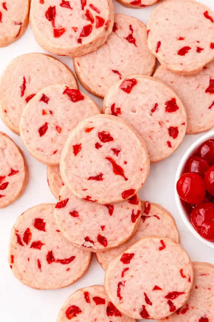 Cherry almond shortbread cookies with maraschino cherries in a white bowl