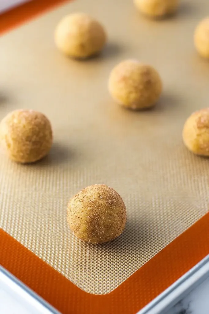 Chewy Snickerdoodle Cookies – Ultimate Soft Holiday Treat 26 Chewy snickerdoodle cookie dough balls on a baking sheet before baking