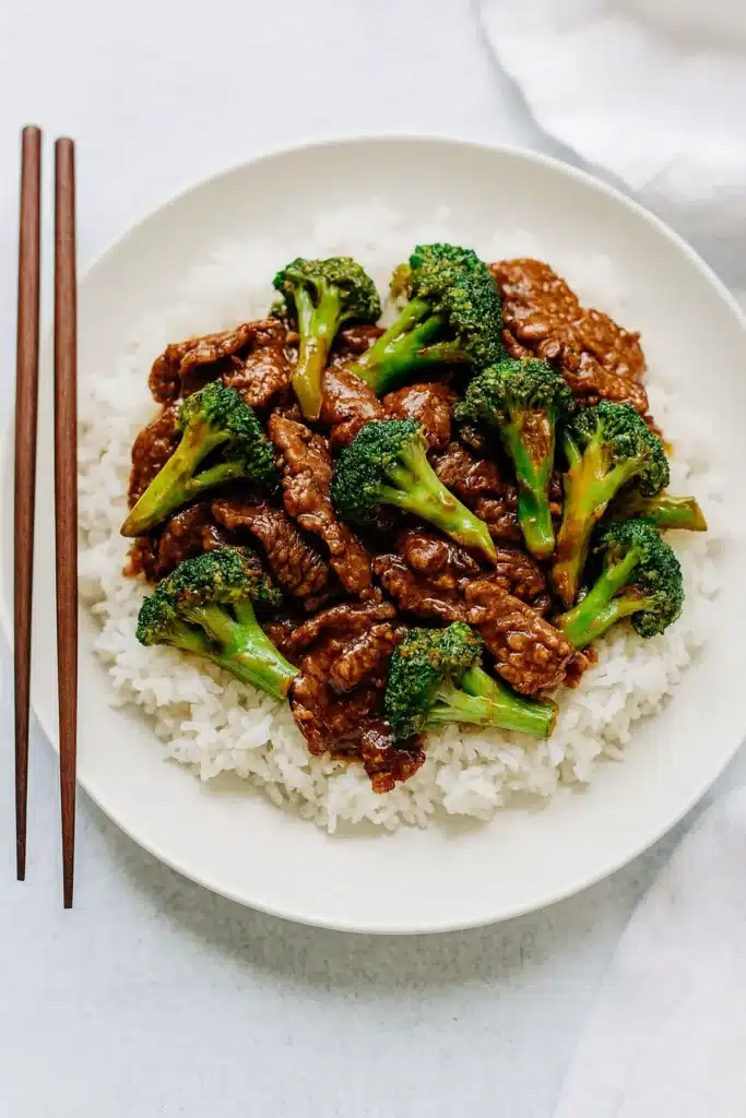 Chinese beef and broccoli served over rice in a rustic bowl