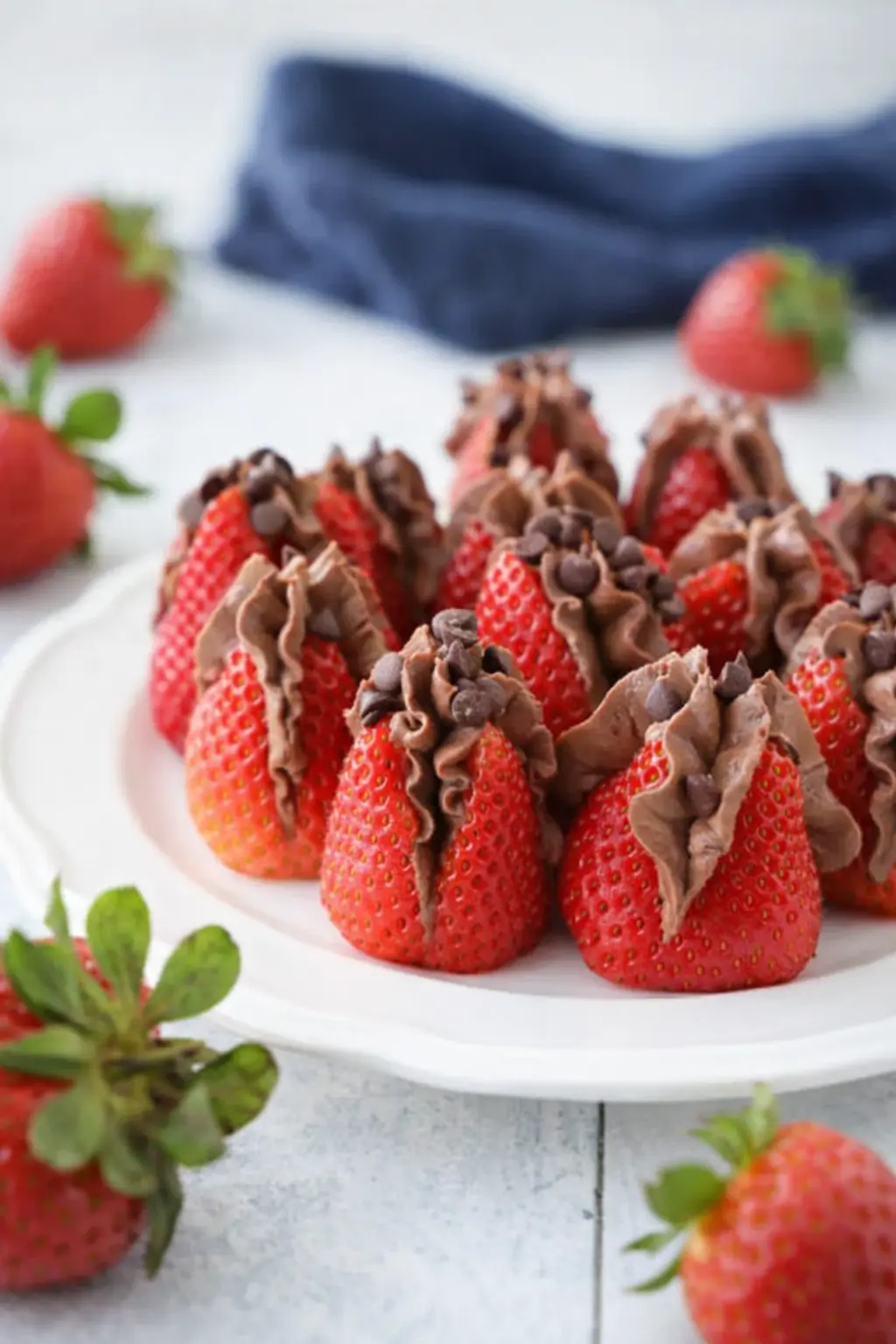 Chocolate cheesecake stuffed strawberries on a white-gray table with creamy chocolate filling