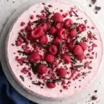 Chocolate raspberry mousse cake topped with fresh raspberries and chocolate curls