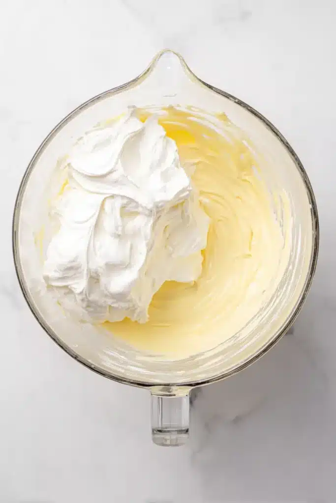 Christmas Cookie Lush Recipe | Easy, Festive & Delicious 26 Cream cheese mixture and whipped topping in a bowl for Christmas Cookie Lush