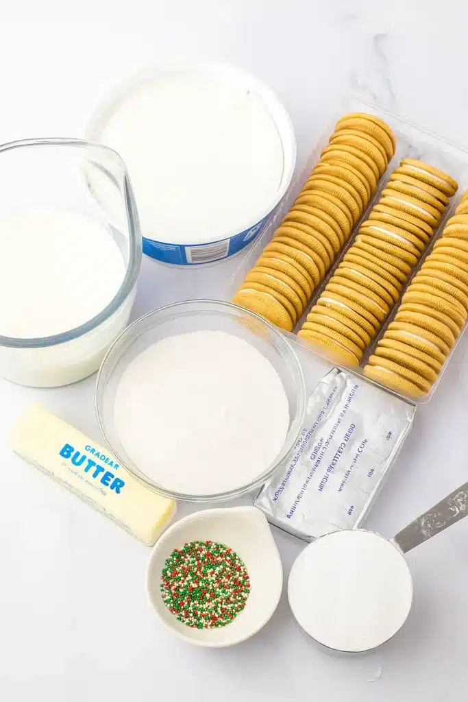 Christmas Cookie Lush Recipe | Easy, Festive & Delicious 21 Christmas Cookie Lush ingredients on white marble with cookies, butter, and sprinkles