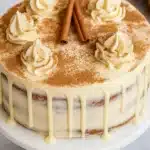 Christmas spice cake with eggnog frosting and cinnamon sticks on top