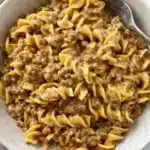 Creamy beef and noodles in a white bowl on marble surface