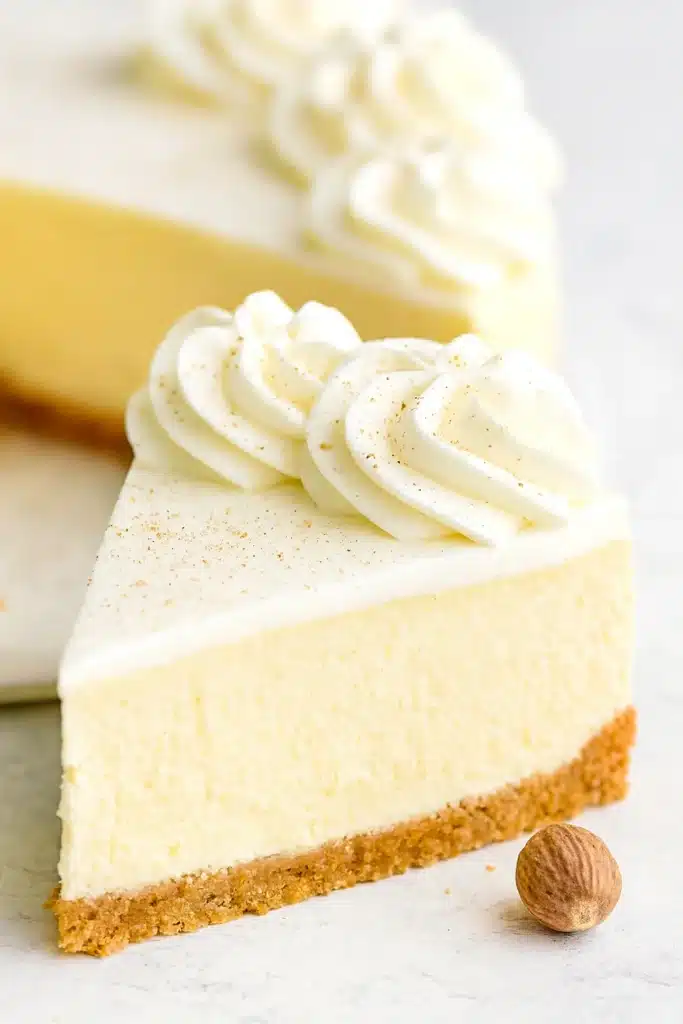 Eggnog Cheesecake – A Creamy, Festive Holiday Dessert 12 Slice of eggnog cheesecake with whipped cream and nutmeg on top