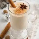 Homemade eggnog in a glass mug with cinnamon and star anise garnish