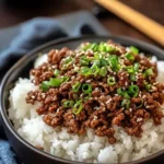 Delicious Korean Ground Beef Bowl with rice, sesame seeds, and green onions in a white bowl