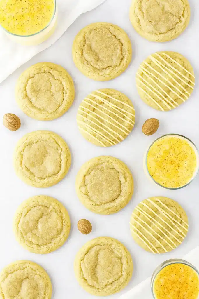 Eggnog Cookies | Soft, Chewy & Perfect for the Holidays 7 Top-down view of soft eggnog cookies with icing on gray table and white napkin