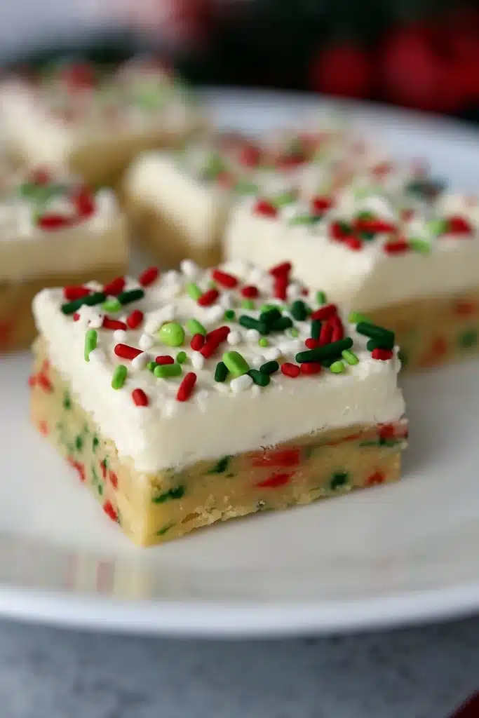 Christmas cookie bars topped with white frosting and red and green sprinkles