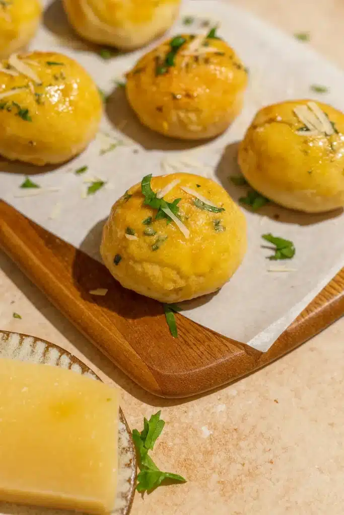 Golden Garlic Parmesan Cheeseburger Bombs on wooden board with parmesan