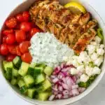 Greek chicken bowl with grilled chicken, feta, tzatziki, and fresh vegetables