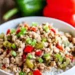 Ground turkey and peppers with rice in a white bowl on gray table