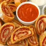 Golden pepperoni rolls with marinara dipping sauce in a parchment-lined basket
