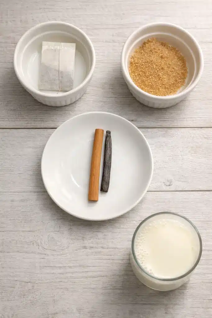 Homemade Vanilla Cinnamon Milk Tea ingredients on a light wooden table