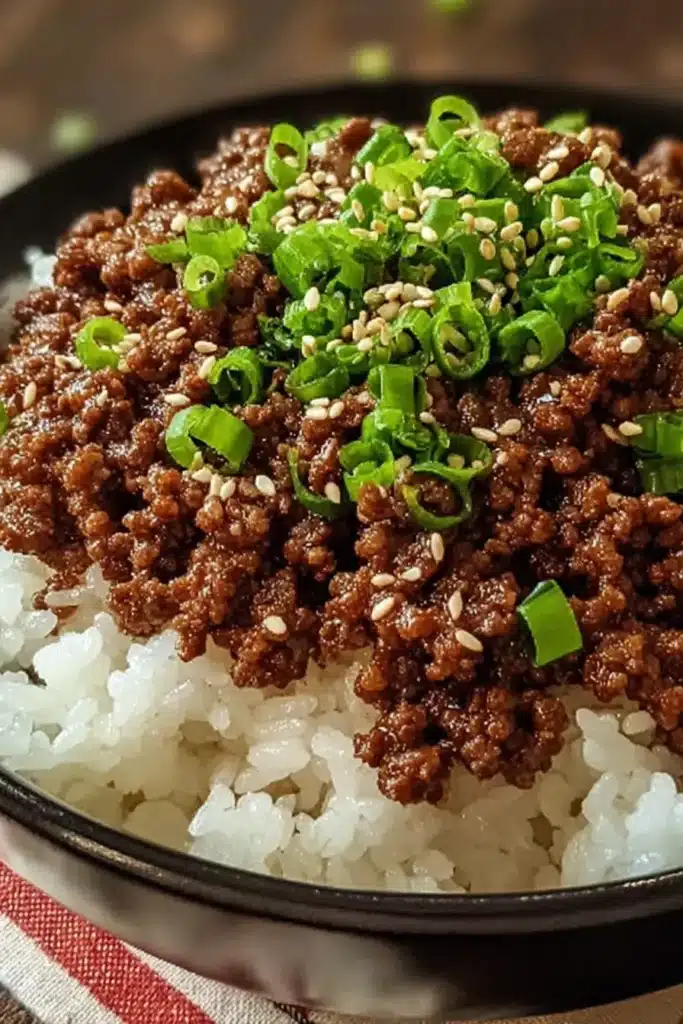 Korean ground beef bowl close-up with sesame seeds and green onions over rice