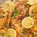 Golden lemon chicken with lemon butter sauce and parsley garnish