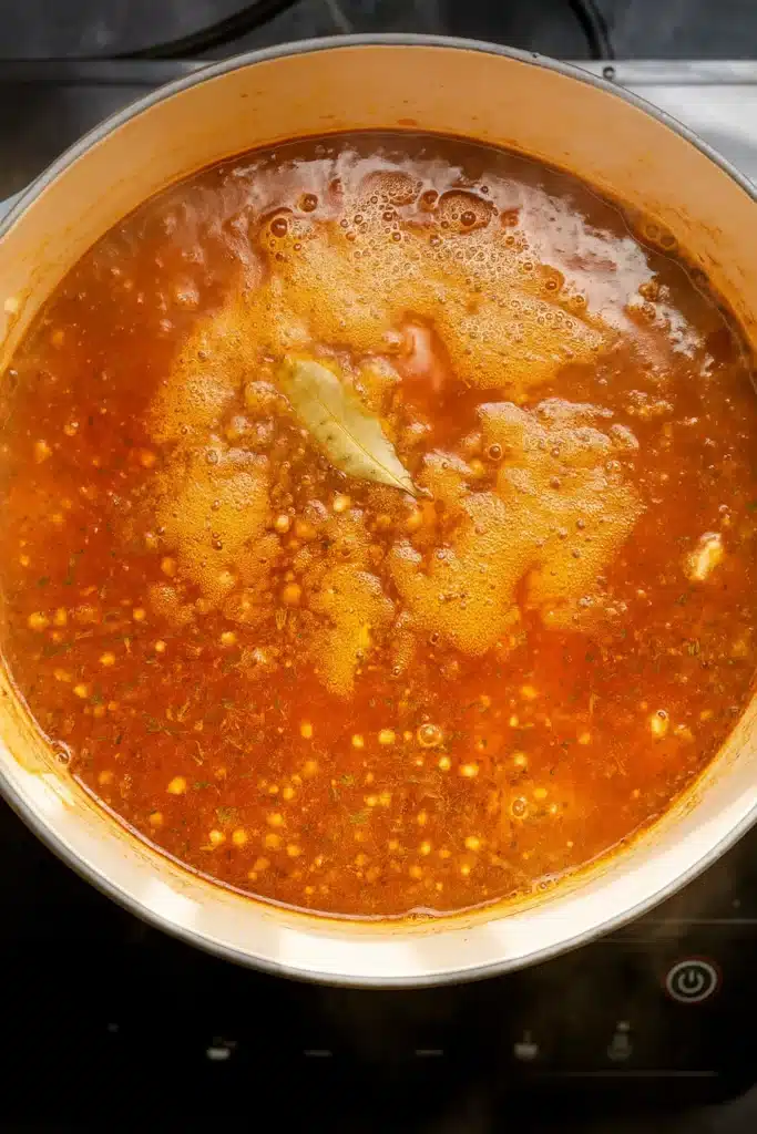 Simmering lentil potato soup in a Dutch oven with tomato broth