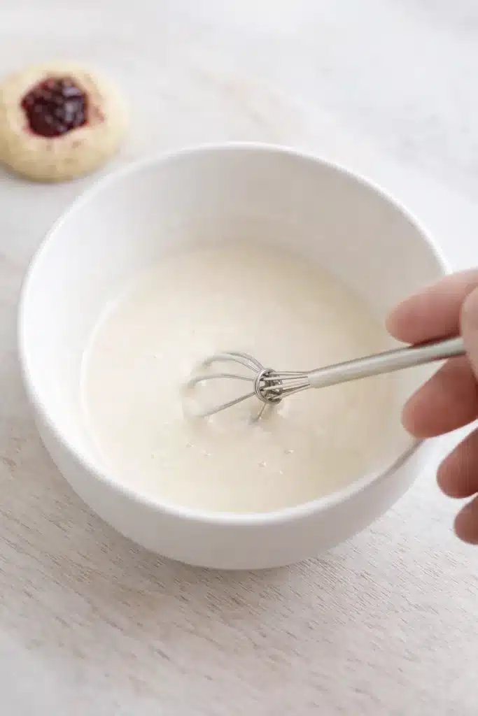 Raspberry Thumbprint Cookies with Icing – Simple Joy 12 Whisking smooth vanilla icing for raspberry thumbprint cookies