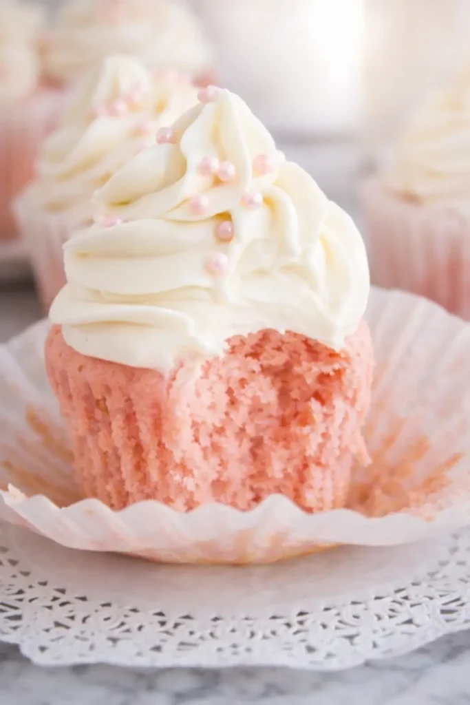 Pink Velvet Cupcakes: Soft, Sweet, and Perfectly Pink 4 Pink velvet cupcake with creamy frosting and a bite showing fluffy texture