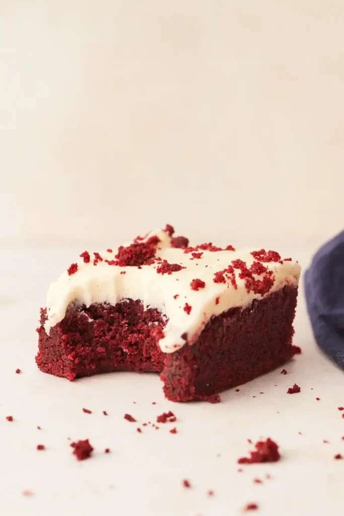 Red Velvet Brownies | Ultimate Fudgy Treat Recipe 15 Partially eaten red velvet brownie with creamy frosting and red crumbs
