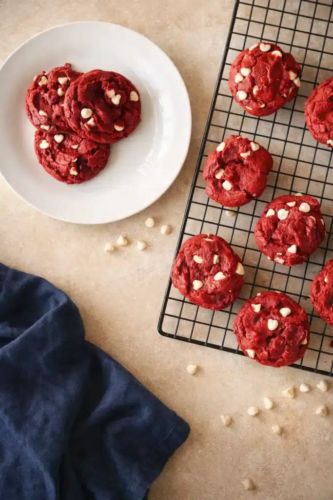 Red velvet cake mix cookies cooling on a rack with white chocolate chips