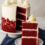 Red velvet cake with cream cheese frosting on white plate