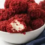 Red velvet cheesecake balls with creamy centers in a white bowl