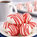 Red velvet cheesecake bites with white chocolate coating and red drizzle